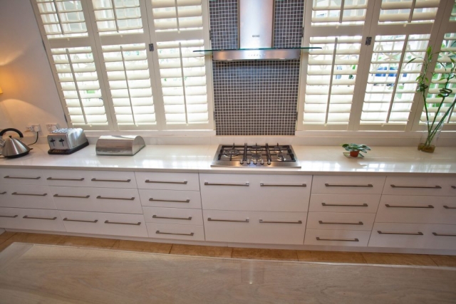 2k MDF painted white kitchen with gas hob and extractor and units to all have horizontal handles