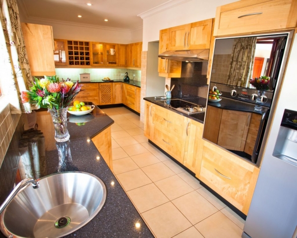 Natural Jacaranda Shaker kitchen with double eye level oven, electric and gas hob, prep bowl, cabinet ligjts and local Stargate Granite