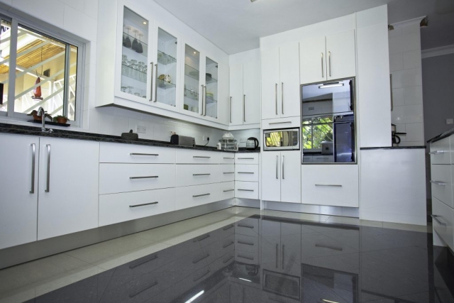 white panited high gloss kitchen with double eye level oven and eye level micowave unit