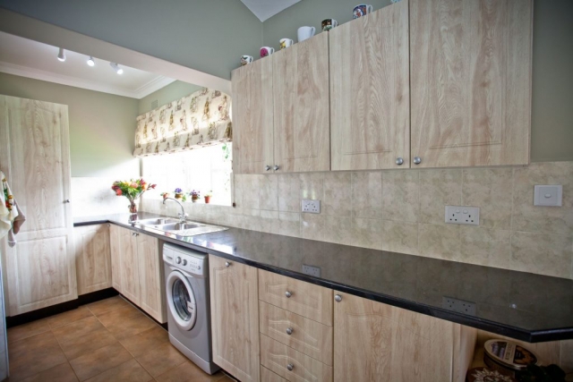 Amber oak PVC wrappe kitchen with local granite tops double sink and washing machine