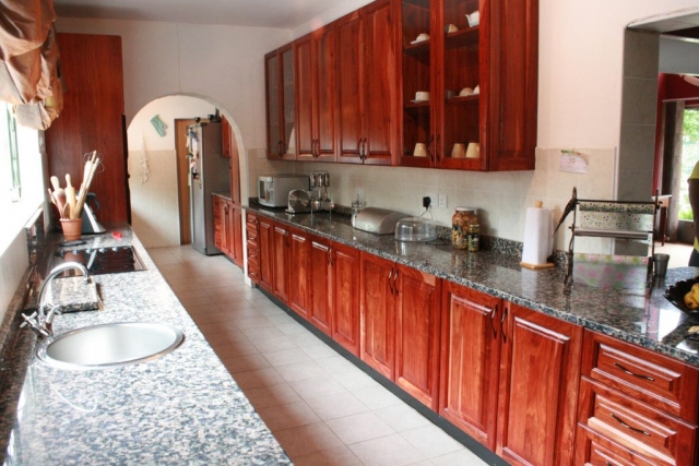 Natural Zimbabwean teak raised panel kitchen with prep bowl and electic hob